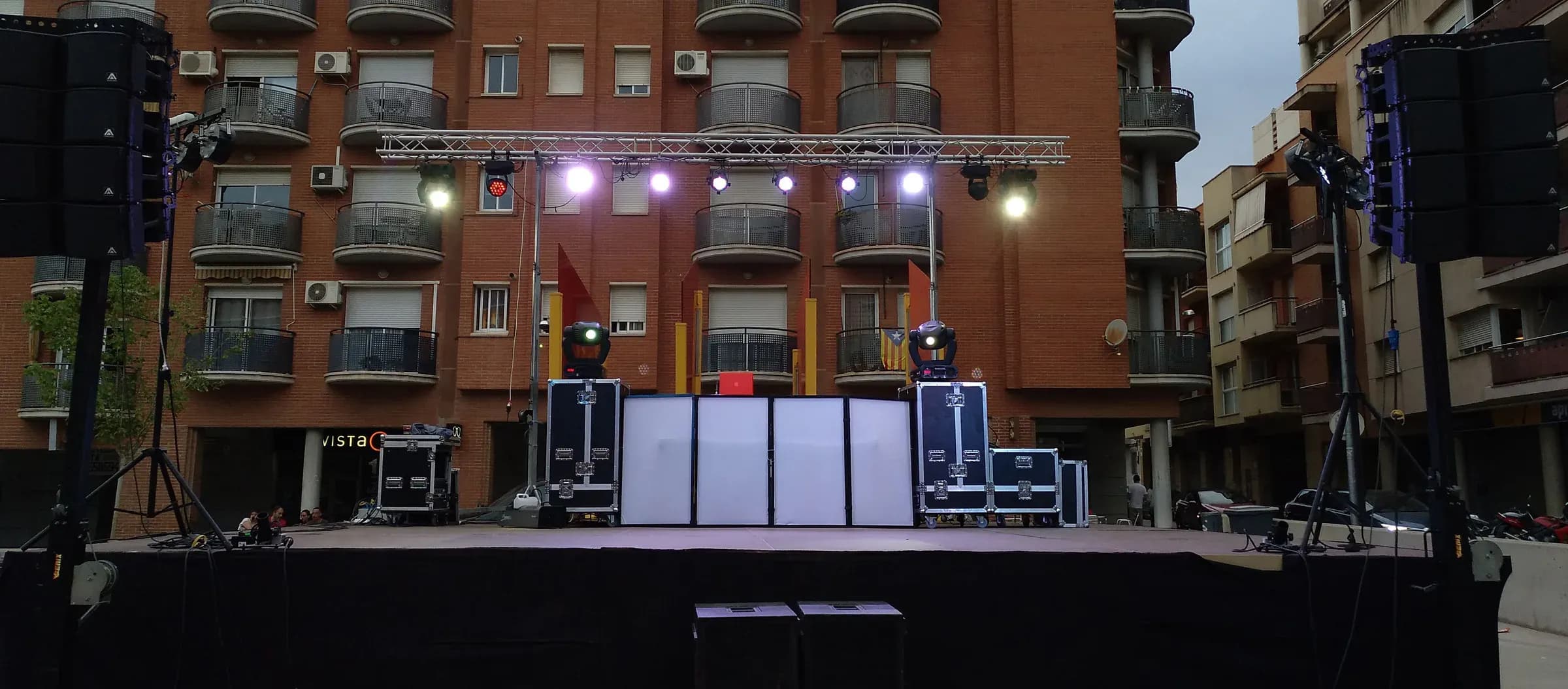 Cabina de discomovil montada en plaza con altavoces line array y truss de iluminacion antes del evento