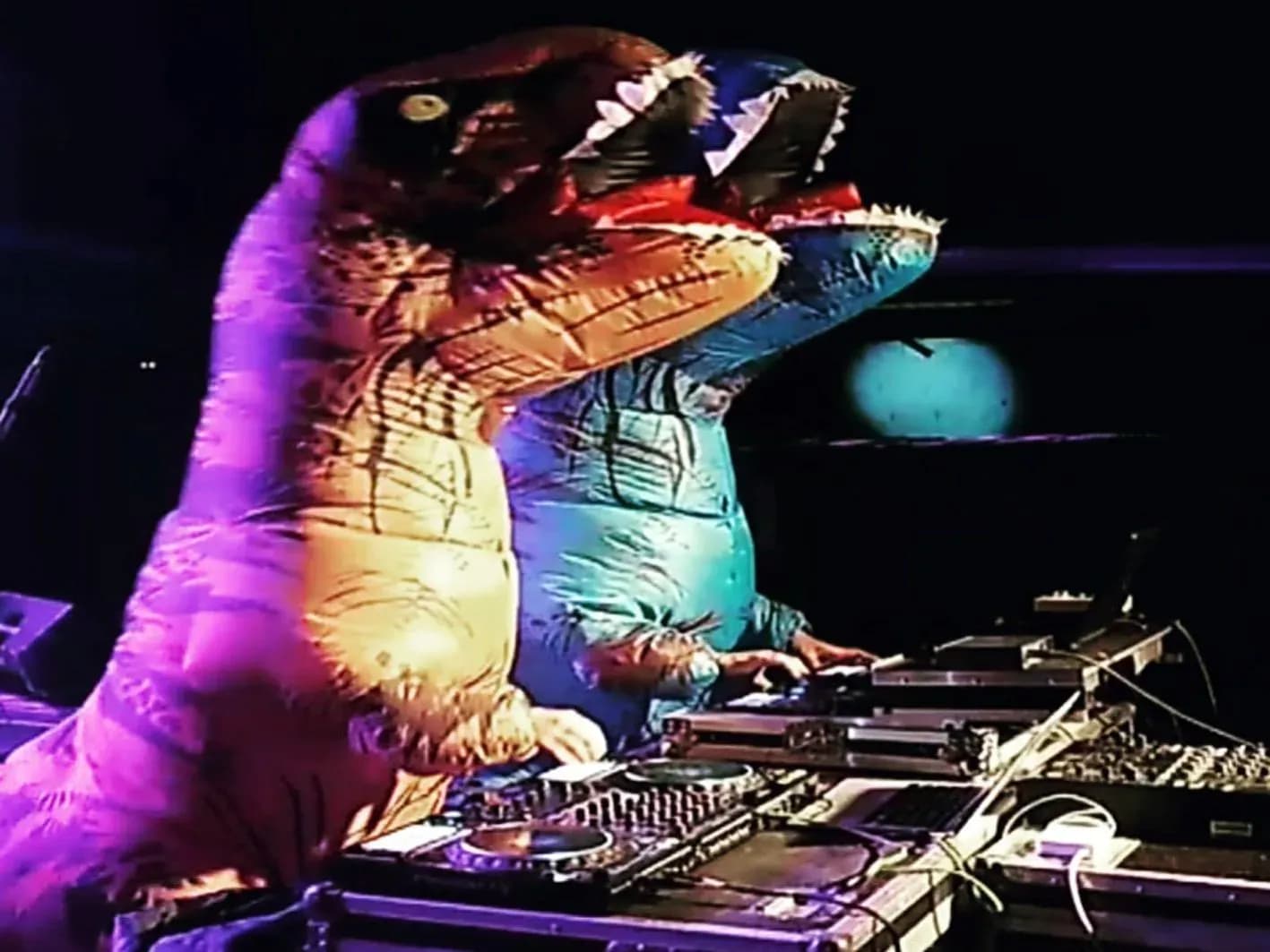 DJ Hunder Button pinchando disfrazado con traje hinchable de dinosaurio sobre los platos