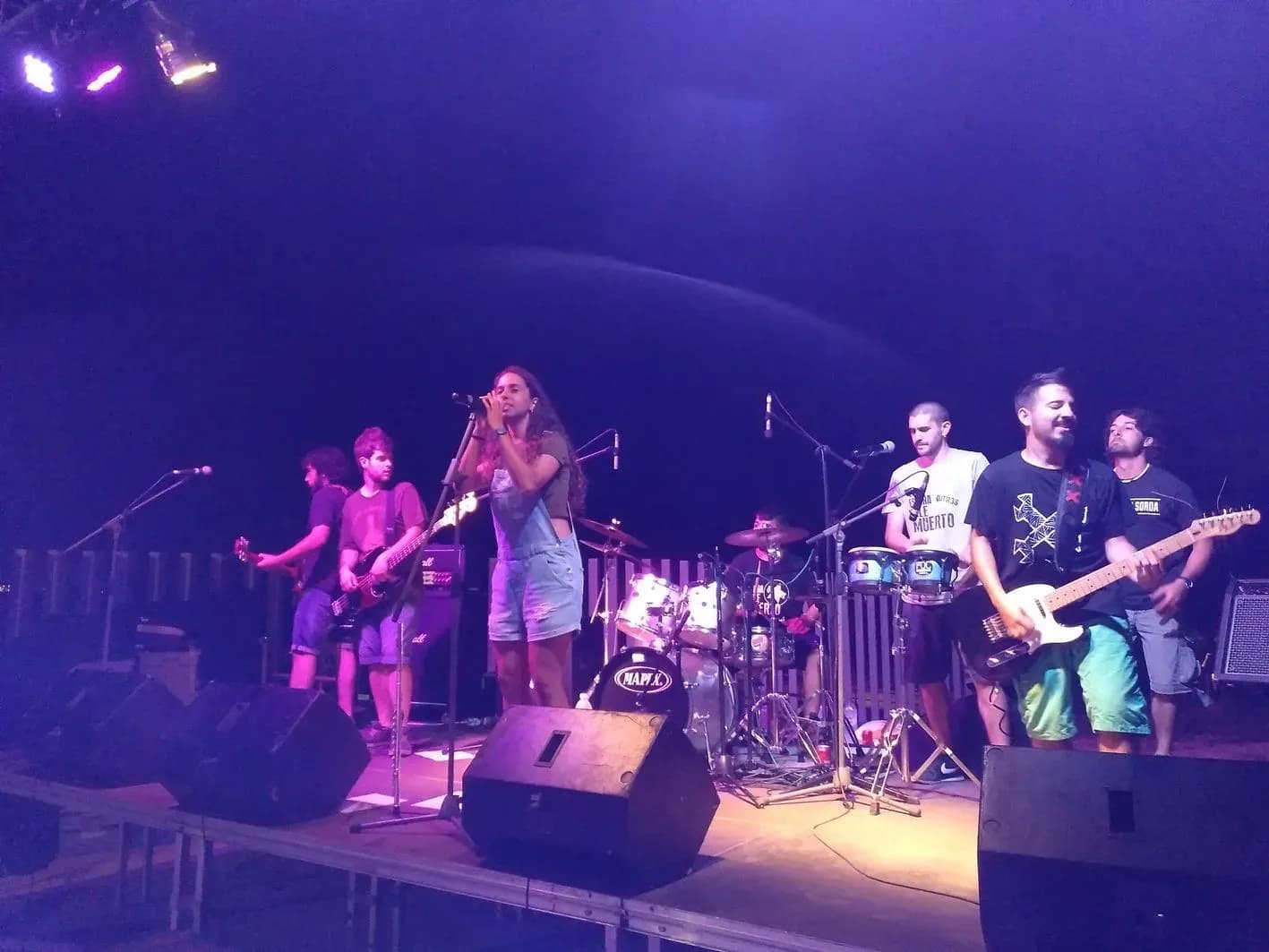 Equipo de sonorizacion e iluminacion con focos moviles y cabina DJ montados en escenario antes del evento