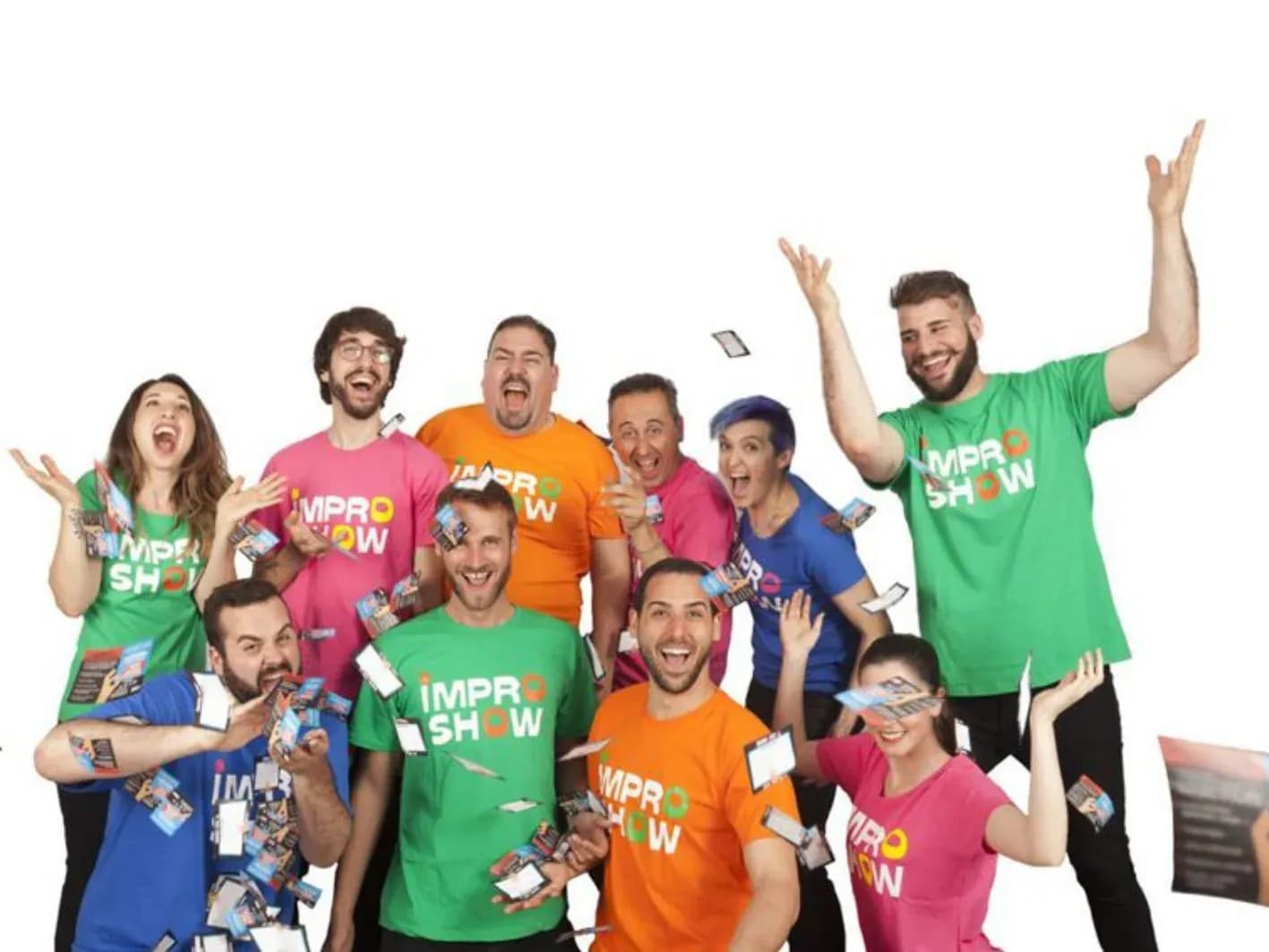 Cinco actores de Impro Show con camisetas de colores y entradas en las manos posando con sonrisa amplia sobre fondo blanco